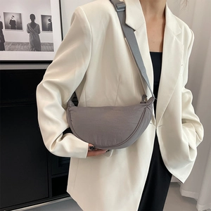 Minimalist grey-purple nylon crescent crossbody bag with adjustable wide strap on a model