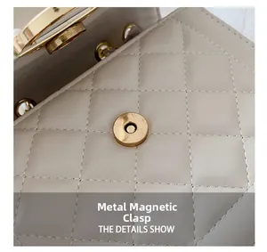 Detailed macro view of golden cylindrical magnetic clasp on cream quilted leather bag