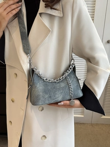 Retro grey denim crescent shoulder bag with silver chain and wide strap on model