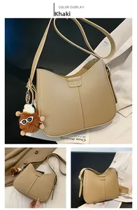 Detail of khaki PU leather shoulder bag with FASHION label and plush ball charm