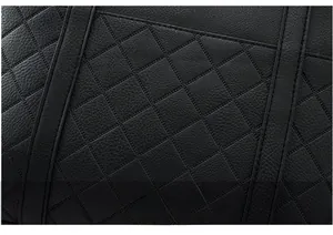 Close-up of black quilted leather texture with premium stitching details on tote bag