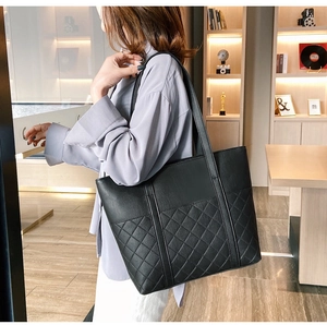 Close-up of black quilted tote bag with large capacity and elegant shoulder straps