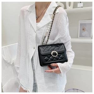 Close-up of quilted chain bag featuring elegant pearl buckle and metal strap details