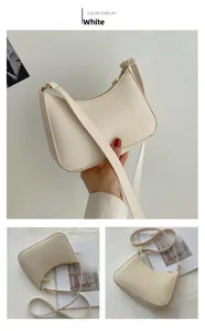 Detailed view of white half-moon shoulder bag with minimalist golden zipper and PU texture
