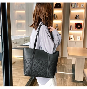 Close-up of black PU leather tote bag featuring classic diamond quilted stitching details