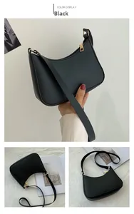 Detail view of black matte leather crescent bag with gold zipper and adjustable strap