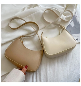 Detail of minimalist crescent moon bags in beige and cream with smooth PU leather texture