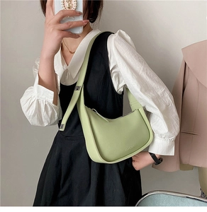 Detail view of adjustable shoulder strap and logo on light green leather hobo bag