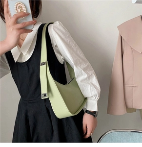 Detail of light green hobo bag showing adjustable strap and square metal buckle