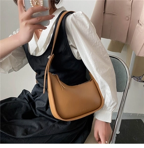 Brown faux leather crescent underarm bag with adjustable strap and embossed detail