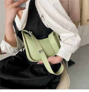 Detail of light green crescent underarm bag with wide strap and silver metal buckle