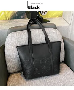 Close-up of black leather tote bag featuring detailed rose embossed floral patterns