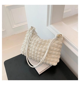 Detail of creamy white pleated underarm bag with bubble texture and rope handle