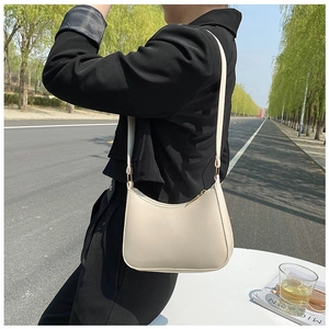 Minimalist cream white half-moon underarm bag with zipper closure and thin shoulder strap