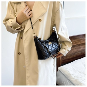 Detail of black quilted leather shoulder bag with gold twist lock and chain strap