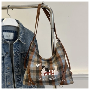 Detail of vintage plaid shoulder bag featuring cartoon puppy print and leather straps