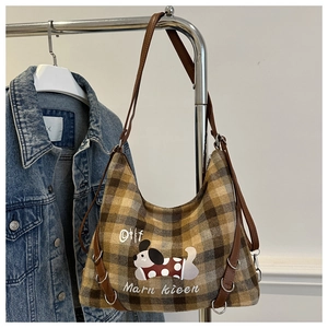 Close-up of a plaid wool tote bag featuring a cute cartoon puppy and brown leather trim