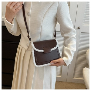 Detail of crossbody bag with brown leather and white fuzzy faux fur trim texture