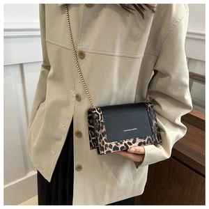 Détail du sac bandoulière à motif léopard avec chaîne dorée porté par un mannequin