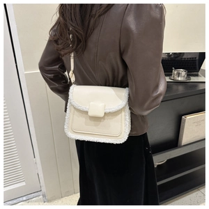 Détail d'un sac bandoulière vintage blanc cassé avec bordure en fausse fourrure blanche