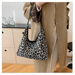 Detail of hobo bag with leopard print jacquard fabric and black leather strap