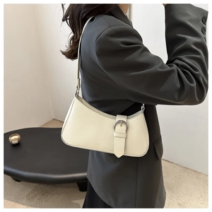Chic cream white crescent underarm bag with silver ring buckle styled on a grey blazer