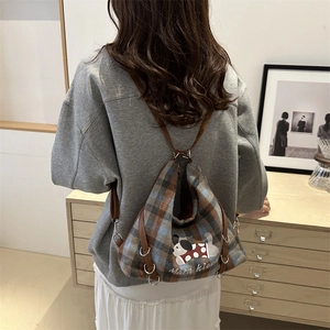 Retro plaid tote bag with dog print and brown leather straps in a home setting
