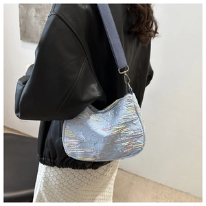 Détail du sac bandoulière bleu clair avec broderie colorée et large sangle en tissu
