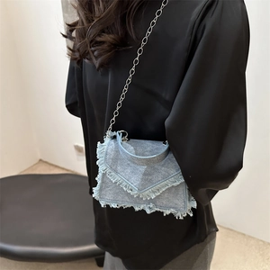 Chic light blue denim crossbody bag with fringe edges and a silver chain strap