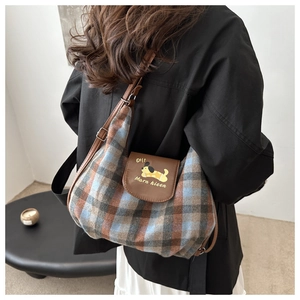 Detail of plaid crossbody bag with cartoon dog embroidery and brown leather strap