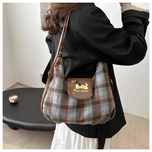 Detail of checkered shoulder bag with cartoon dog print and leather flap closure