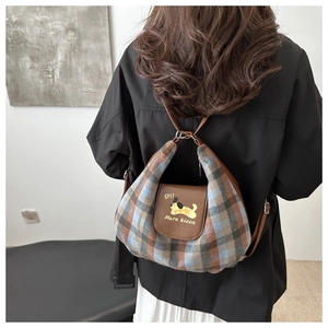 Detail of plaid tweed shoulder bag with leather flap and cartoon dog embroidery