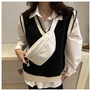 Detail of white checkered crossbody chest bag with double zippers and wide woven strap