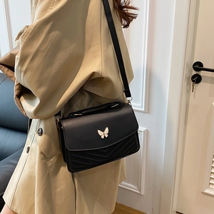 Vintage black crossbody bag with V-shaped quilting and a silver butterfly buckle