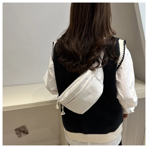 Rear view of a model wearing a white nylon crescent bag with textured grid patterns