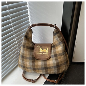 Detail of retro plaid hobo bag with cartoon dog print and brown leather handles