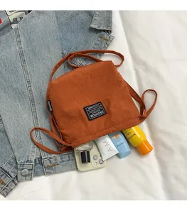 Top view of large capacity orange nylon crossbody bucket bag filled with daily items