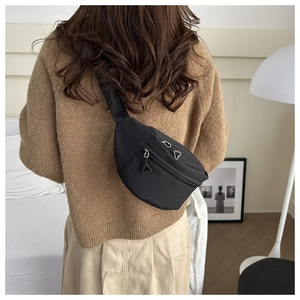 Model wearing black textured nylon chest bag showing double zippers and adjustable strap