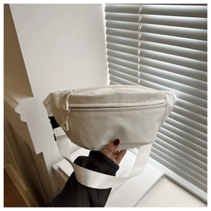 Dettaglio del marsupio bianco a scacchi con cerniera a triangolo e tracolla in tessuto