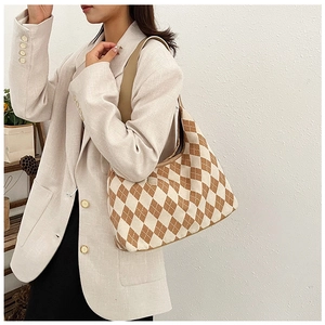 Detail of knitted diamond pattern tote bag in brown and cream with leather strap