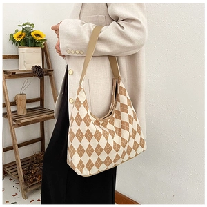 Close-up of hobo tote bag featuring argyle pattern and brown leather shoulder strap