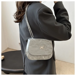 Detail of silver chain shoulder bag with butterfly logo and pleated texture