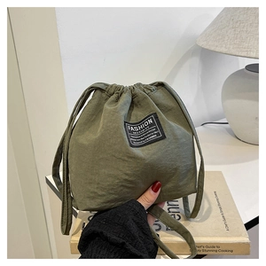Detail view of army green nylon bucket bag with fashion drawstring and texture