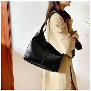Side view of large black leather hobo bag on shoulder, showing high-capacity design