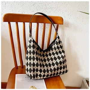Detail of hobo tote bag with black and white argyle pattern hanging on a wooden chair
