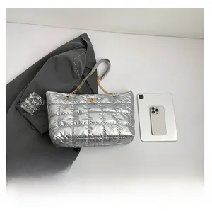 Silver quilted tote bag with elk logo showing high capacity next to a tablet