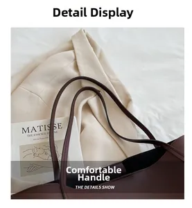 Detail view of deep brown leather tote bag with slim handles and matte finish