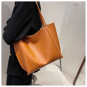 Caramel PU leather tote bag shown on shoulder with minimalist commuter style