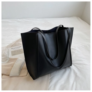 Detail of minimalist black tote bag with long shoulder straps for daily commuting
