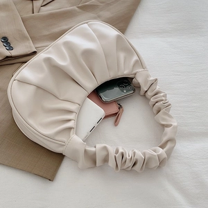 Interior view of off-white pleated crescent bag showing space for phone and essentials